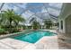 Inviting screened-in pool with travertine deck, lush landscaping, and ample space for entertaining at 23420 Peachland Blvd, Port Charlotte, FL 33954