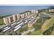 Aerial view of the condominium complex with parking and lush green spaces near a lake at 2615 Cove Cay Dr # 409, Clearwater, FL 33760