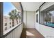 The covered balcony has a carpeted floor and a lovely view of a palm tree and surrounding buildings at 2615 Cove Cay Dr # 409, Clearwater, FL 33760