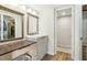 Bathroom with wood vanity and mirror, updated lighting, and open closet at 2615 Cove Cay Dr # 409, Clearwater, FL 33760