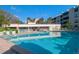 Community pool with clear blue water, lounge chairs, and a nearby recreation center at 2615 Cove Cay Dr # 409, Clearwater, FL 33760