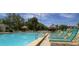 Community pool with many lounge chairs and tropical umbrellas and an American flag at 2615 Cove Cay Dr # 409, Clearwater, FL 33760