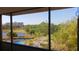 Screened in porch view of pool, landscaping, lake, and American Flag at 2615 Cove Cay Dr # 409, Clearwater, FL 33760