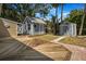 Spacious backyard with wooden deck, storage sheds, and lush greenery at 2728 58Th S St, Gulfport, FL 33707