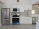 Charming kitchen features white cabinets, stainless steel appliances, tile backsplash, and wood-look flooring at 2728 58Th S St, Gulfport, FL 33707