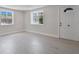 Bright living room with fresh white paint, wood-look tile floors, and two windows at 2728 58Th S St, Gulfport, FL 33707