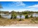 A lovely pond view shows a calm lake with a sign, greenery, and a clear blue sky above at 2728 58Th S St, Gulfport, FL 33707