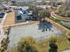 Aerial view of the community basketball court with basketball hoops and benches surrounded by trees at 3046 Donington Castle Ln, Land O Lakes, FL 34638
