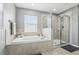 Well-lit bathroom boasting a soaking tub with a window view, a separate shower, and neutral tile flooring at 3046 Donington Castle Ln, Land O Lakes, FL 34638
