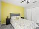Bedroom features a yellow accent wall, closet, ceiling fan, and a window, offering a cozy retreat at 3046 Donington Castle Ln, Land O Lakes, FL 34638