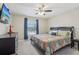 Bright bedroom features a ceiling fan, TV, and window providing natural light, creating a welcoming space at 3046 Donington Castle Ln, Land O Lakes, FL 34638