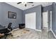 Comfortable bedroom features gray walls, wood flooring, a window and a closet with a closed door at 3046 Donington Castle Ln, Land O Lakes, FL 34638