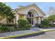 Beautiful clubhouse exterior featuring an arched entrance, columns, and lush landscaping at 3046 Donington Castle Ln, Land O Lakes, FL 34638