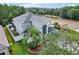 Two-story home featuring gray exterior, arched entryway, manicured landscaping, and a side-entry two car garage at 3046 Donington Castle Ln, Land O Lakes, FL 34638