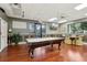 Entertaining game room with a billiard table, seating, and a large window overlooking the outdoors at 3046 Donington Castle Ln, Land O Lakes, FL 34638