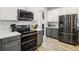 Updated kitchen featuring stainless steel appliances, stylish two-tone cabinets, quartz countertops, and wood-look flooring at 3046 Donington Castle Ln, Land O Lakes, FL 34638