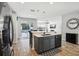 Modern kitchen with island, stainless steel appliances, and wood-look tile flooring. The open layout connects to the outdoor pool area at 3046 Donington Castle Ln, Land O Lakes, FL 34638