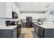 Bright kitchen with stainless steel appliances, white and gray cabinets, an island with seating, and modern wood-look flooring at 3046 Donington Castle Ln, Land O Lakes, FL 34638