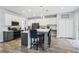Spacious eat-in kitchen featuring two-tone cabinets, an island with seating, stainless steel appliances, and wood-look floors at 3046 Donington Castle Ln, Land O Lakes, FL 34638