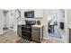 Updated kitchen with black appliances, two-tone cabinets, quartz countertops, wood-look flooring, and open dining room views at 3046 Donington Castle Ln, Land O Lakes, FL 34638