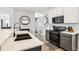 Modern kitchen with black appliances, two-tone cabinets, quartz countertops, and wood-look floors, leading to stairway at 3046 Donington Castle Ln, Land O Lakes, FL 34638
