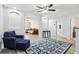 Cozy upstairs loft area with neutral walls, bright windows, comfy chair, and a colorful rug at 3046 Donington Castle Ln, Land O Lakes, FL 34638