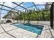 Relaxing screened-in pool with spa and stylish stone patio, perfect for outdoor entertaining at 3046 Donington Castle Ln, Land O Lakes, FL 34638