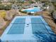 Aerial view of community tennis courts with nets and surrounding landscape at 3046 Donington Castle Ln, Land O Lakes, FL 34638