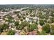 This home features an aerial view of a residential neighborhood with tree-lined streets and nearby shops and restaurants at 3603 E Sterling Cir, Tampa, FL 33629