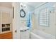 Bathroom featuring blue and white tile, a shower-tub combo, and an ornate mirror at 3603 E Sterling Cir, Tampa, FL 33629