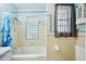 Bright bathroom featuring a shower-tub combo, tile surround, and blue accents at 3603 E Sterling Cir, Tampa, FL 33629