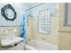 Bathroom with a decorative mirror, pedestal sink, and bathtub with shower at 3603 E Sterling Cir, Tampa, FL 33629