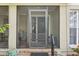 Charming front porch, featuring a secured screen entryway, potted plants and a small sitting area at 3603 E Sterling Cir, Tampa, FL 33629
