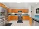 Kitchen featuring stainless steel appliances, oak cabinetry, and tile backsplash at 3603 E Sterling Cir, Tampa, FL 33629