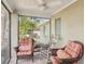 Covered, screened porch with seating, ceiling fan, and view of the backyard at 3603 E Sterling Cir, Tampa, FL 33629