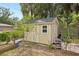 Charming backyard shed with double doors and adjacent garden, offering additional storage at 3603 E Sterling Cir, Tampa, FL 33629