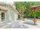 Backyard patio with a tropical design, a custom tiki umbrella, and lush plants at 3714 Village Estates Pl, Tampa, FL 33618
