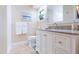 Bright bathroom with white vanity, marble countertop, and a framed beach-themed picture at 3714 Village Estates Pl, Tampa, FL 33618
