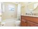 Bathroom with wooden vanity, granite countertops, and a bathtub with shower at 3714 Village Estates Pl, Tampa, FL 33618