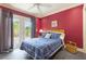 Cozy bedroom featuring a comfortable bed, red accent wall, and access to the outdoors at 3714 Village Estates Pl, Tampa, FL 33618
