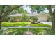 Charming single-story home with lush landscaping, mature trees, and a well-manicured lawn at 3714 Village Estates Pl, Tampa, FL 33618