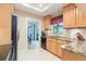Well-lit kitchen with granite countertops, wooden cabinets, and black appliances at 3714 Village Estates Pl, Tampa, FL 33618