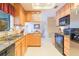 Well-lit kitchen features granite countertops, wood cabinetry, and modern black appliances at 3714 Village Estates Pl, Tampa, FL 33618