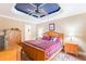 Bedroom features a tray ceiling painted with stars, hardwood floors, and natural wood furniture at 3714 Village Estates Pl, Tampa, FL 33618