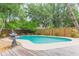 Backyard pool with a fountain, surrounded by lush landscaping and a wooden deck at 3714 Village Estates Pl, Tampa, FL 33618