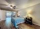 Bedroom with wood-look tile floors, and a view of an adjoined room with shelves at 3932 Watson Dr, New Port Richey, FL 34655