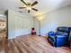 This cozy bedroom shows lovely wood floors, a ceiling fan, a large closet, and a comfortable recliner at 3932 Watson Dr, New Port Richey, FL 34655
