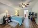 Comfortable bedroom featuring wood-look tile floors, ceiling fan, and neutral walls at 3932 Watson Dr, New Port Richey, FL 34655