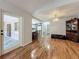 Open living room showcasing wood floors, a view of the kitchen, and an antique cabinet at 3932 Watson Dr, New Port Richey, FL 34655