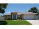 Charming single-story home featuring a manicured lawn and a light blue front door at 404 Oakmount Rd, Clearwater, FL 33765